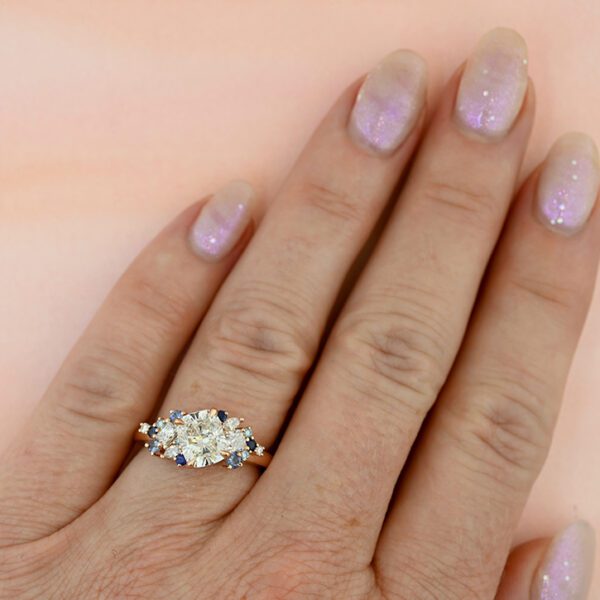 tilted-cushion-diamond-cluster-ring-blue-and-rosy-on-hand