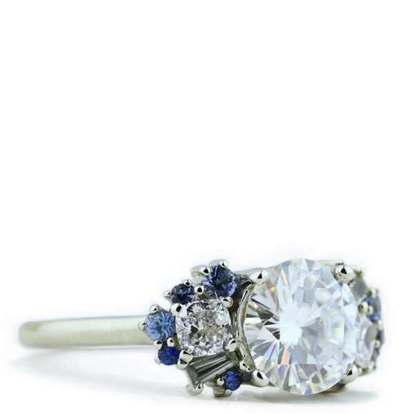 round-moissanite-with-sapphire-accent-engagement-ring-wings-left-view.jpg