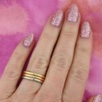 simple-inset-diamond-ring-petite-anything-band-on-hand-pink-backgound