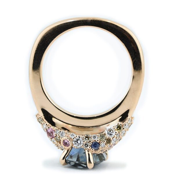 unicorn-sapphire-blue-montana-sapphire-and-pink-champagne-diamond-intricate-ring-through-finger